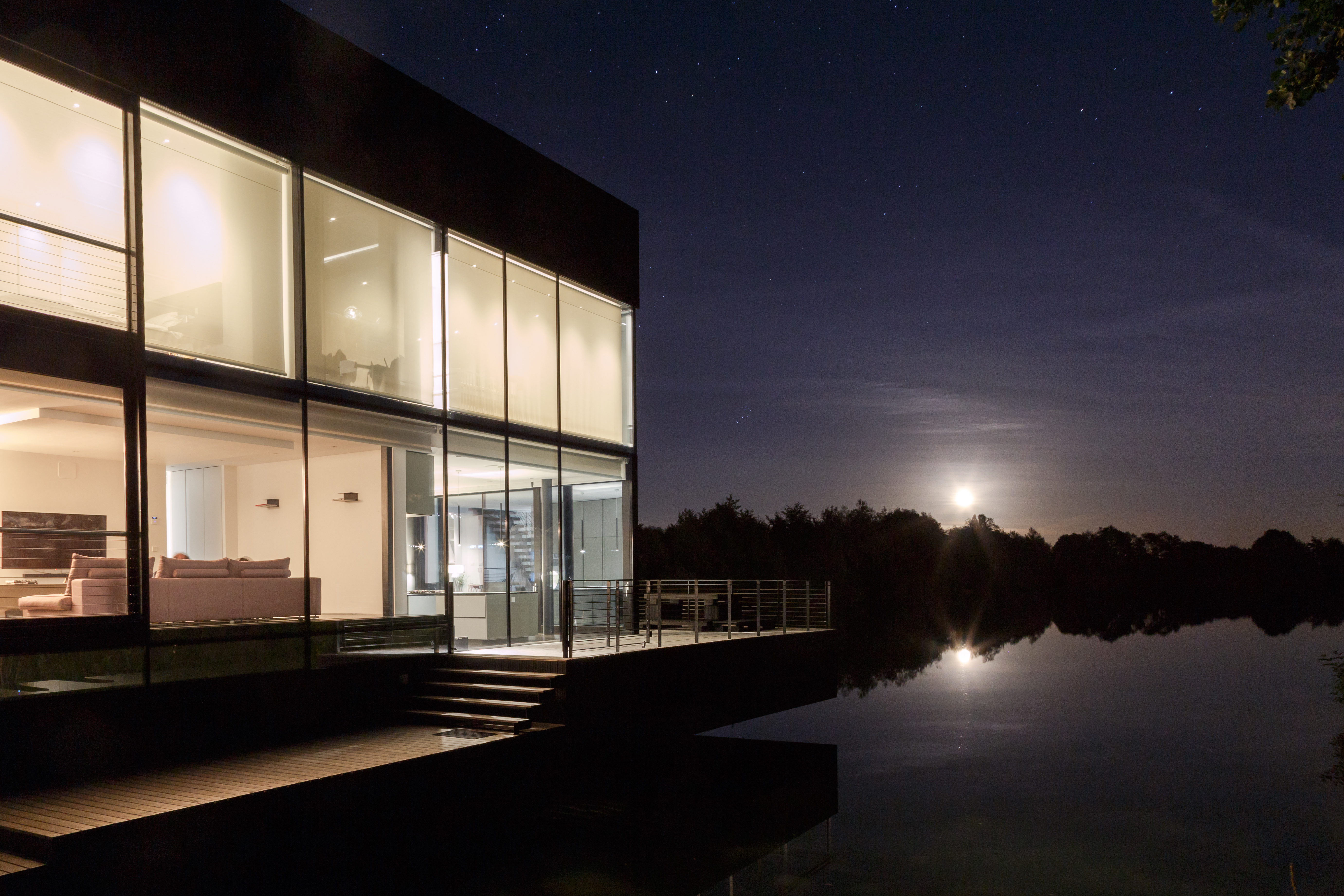 Glass House interior at evening - warm lighting and lake views